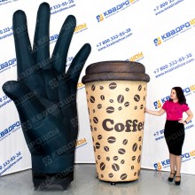 огромная рекламная рука и стаканчик с кофе